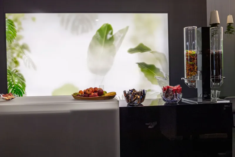 Hinterleuchtete Wand und Schüttgutspender aus PLEXIGLAS®-Rohren in einer Lounge