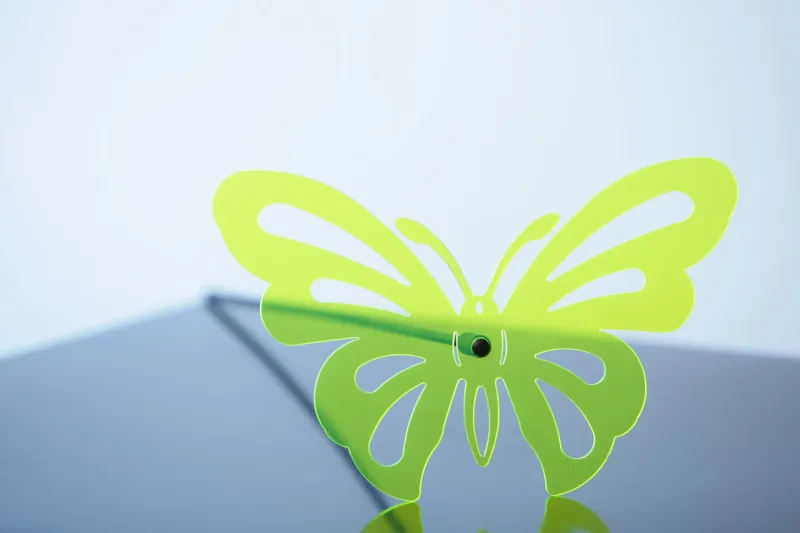 Gelaserter Schmetterling aus grün fluoreszierendem Acrylglas mit leuchtenden Kanten